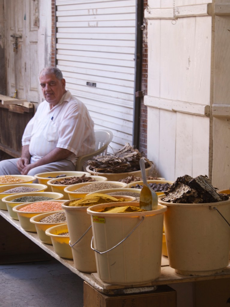 vendor selling spices in manama souk